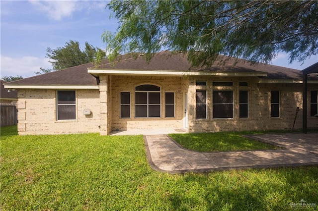907 Amethyst Dr, Weslaco, TX 78596 - back of property with brick siding, a lawn, and a patio area