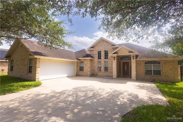 907 Amethyst Dr, Weslaco, TX 78596 - view of front facade featuring brick siding, driveway, and an attached garage