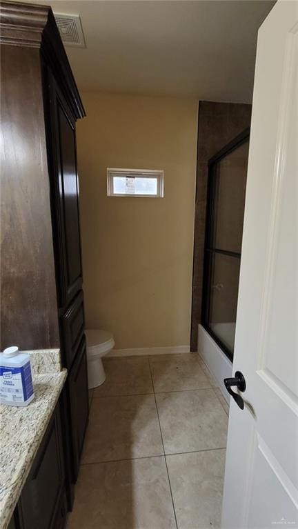 full bathroom with tile patterned floors, vanity, toilet, and enclosed tub / shower combo