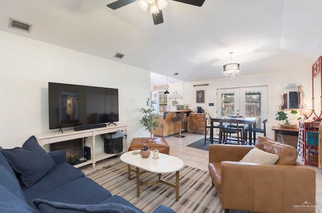 living area with ceiling fan, visible vents, vaulted ceiling, and light tile patterned flooring