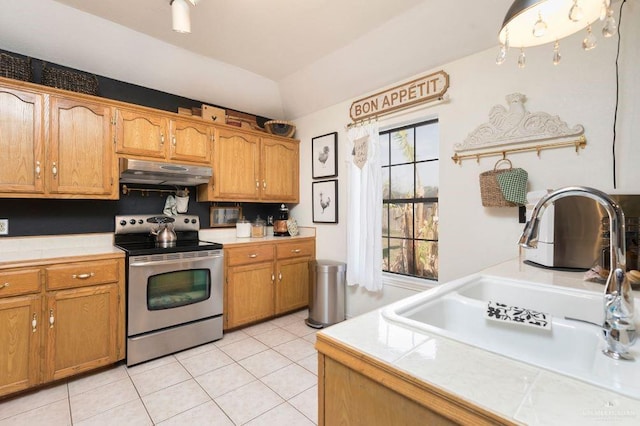 kitchen featuring a sink, under cabinet range hood, stainless steel electric range, and tile countertops