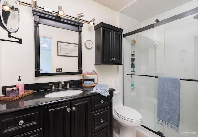 bathroom with toilet, a stall shower, and vanity