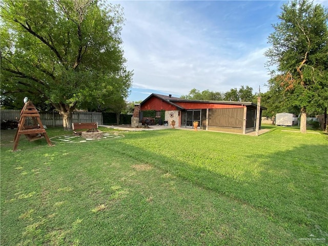 view of yard with a sunroom and an outdoor fire pit