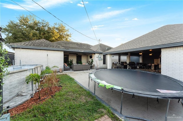 back of house featuring outdoor lounge area, a patio, and a trampoline