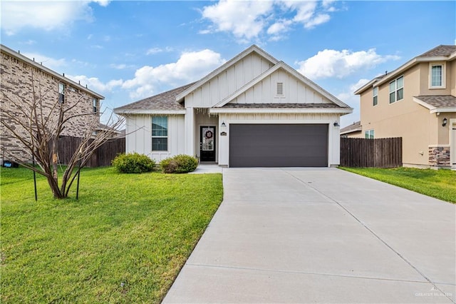 modern farmhouse style home with a garage, concrete driveway, a shingled roof, fence, and a front yard