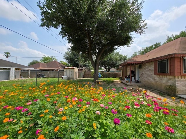 view of yard with a fenced backyard, an outdoor structure, and a shed