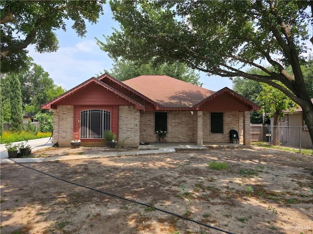 view of front facade with brick siding and fence