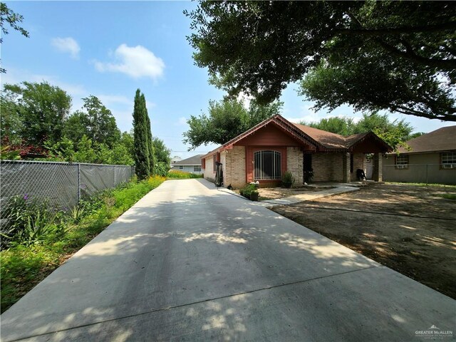view of front of house with fence and concrete driveway