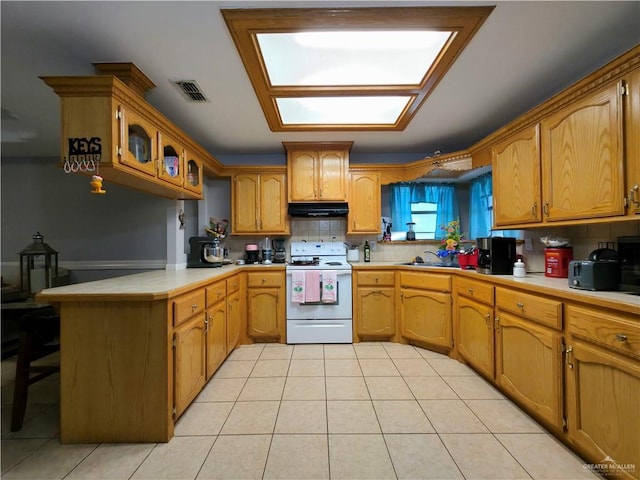 kitchen featuring white electric stove, under cabinet range hood, visible vents, decorative backsplash, and a peninsula