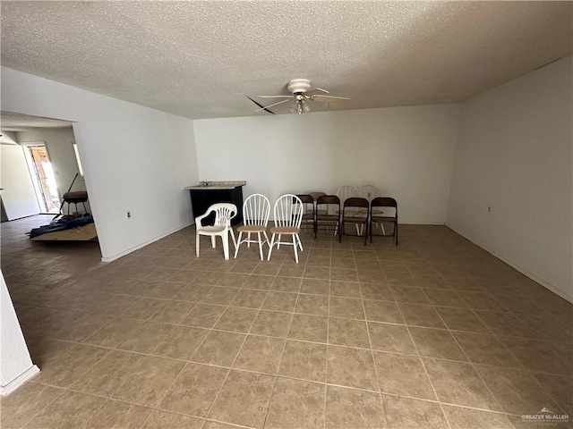 dining room with ceiling fan and a textured ceiling