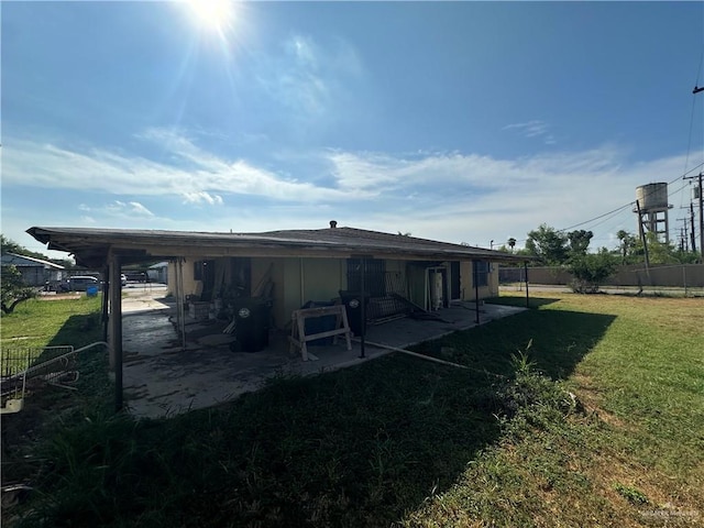 back of house featuring a lawn and a patio area