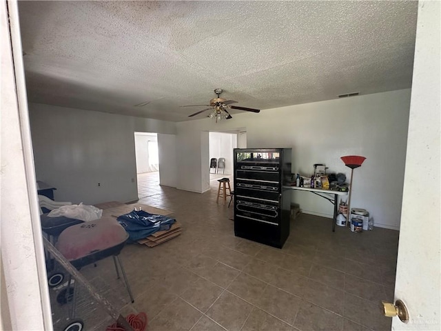 interior space with ceiling fan and a textured ceiling