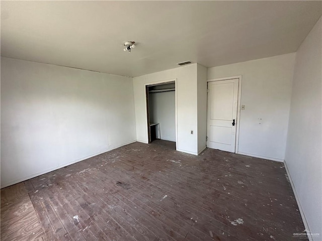 203 N Kansas Ave, Weslaco, TX 78596 - unfurnished bedroom with hardwood / wood-style flooring, baseboards, and a closet