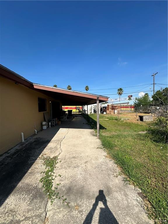 view of parking featuring a yard and a carport