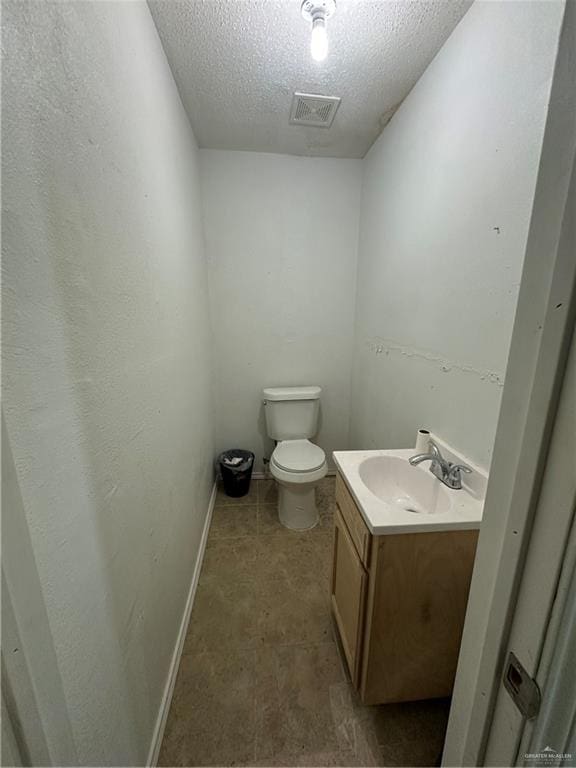 bathroom with vanity, a textured ceiling, and toilet