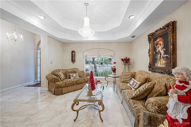 living room with a chandelier, ornamental molding, and a tray ceiling