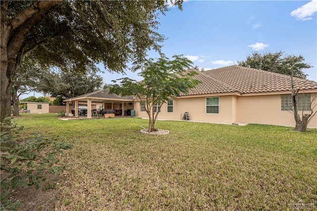 rear view of property with a lawn and a patio area