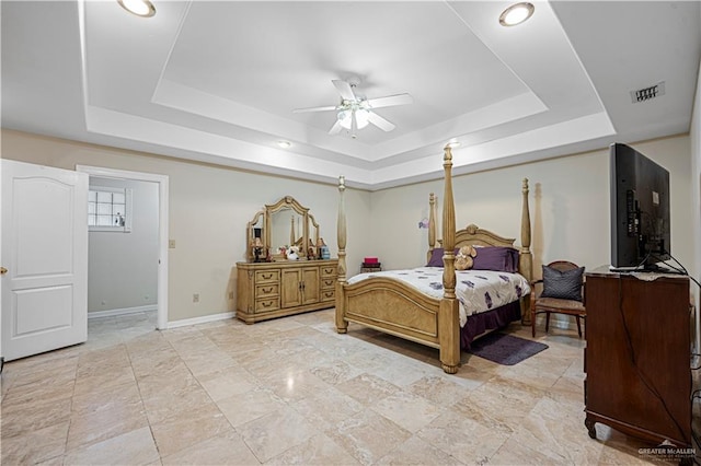 bedroom with a raised ceiling and ceiling fan