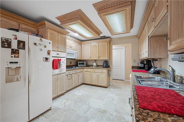 kitchen featuring light brown cabinetry, white appliances, and sink