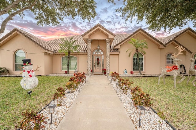 mediterranean / spanish house featuring a lawn