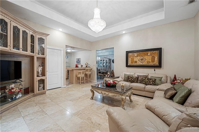 living room with a notable chandelier and a tray ceiling