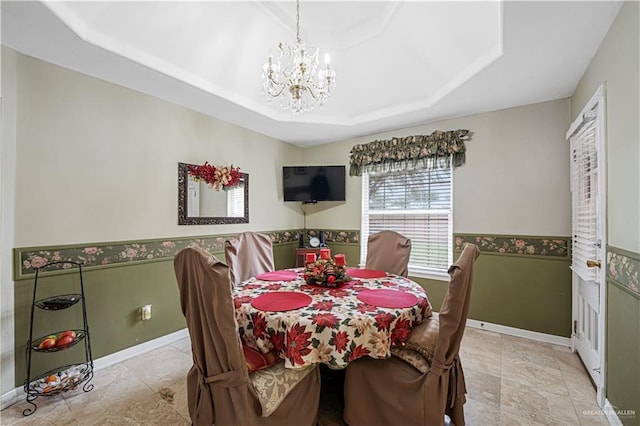 dining space featuring a tray ceiling and an inviting chandelier