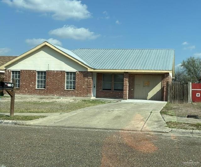 ranch-style house with fence, metal roof, and brick siding