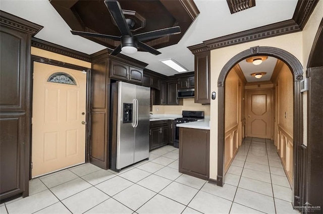 kitchen featuring appliances with stainless steel finishes, ornamental molding, dark brown cabinets, ceiling fan, and light tile patterned floors