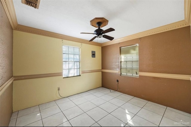 tiled empty room with ceiling fan and ornamental molding