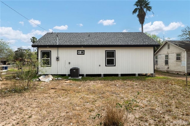 back of property featuring roof with shingles and cooling unit