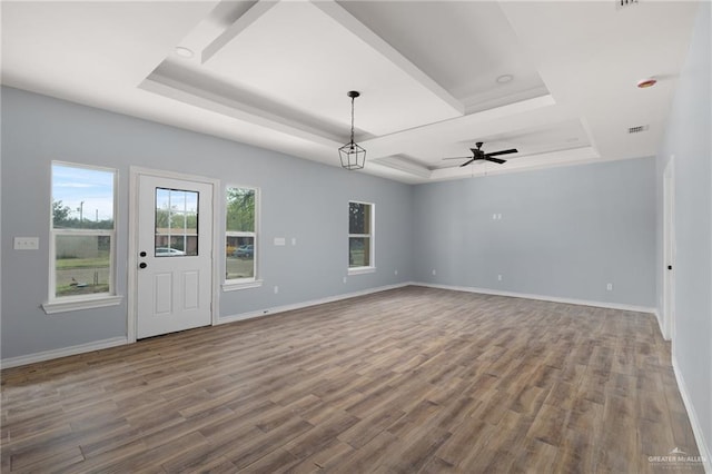 interior space featuring a tray ceiling, ceiling fan, baseboards, and wood finished floors