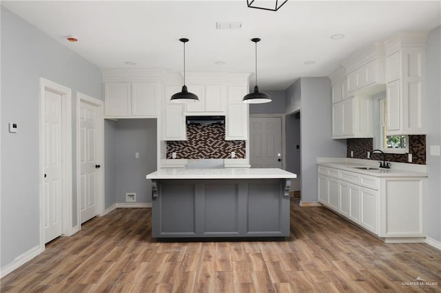 kitchen with light countertops, light wood finished floors, visible vents, and white cabinets