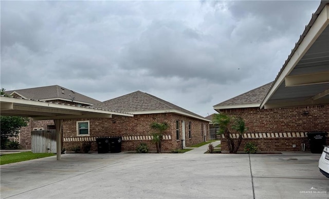 view of property exterior with brick siding, fence, and a shingled roof