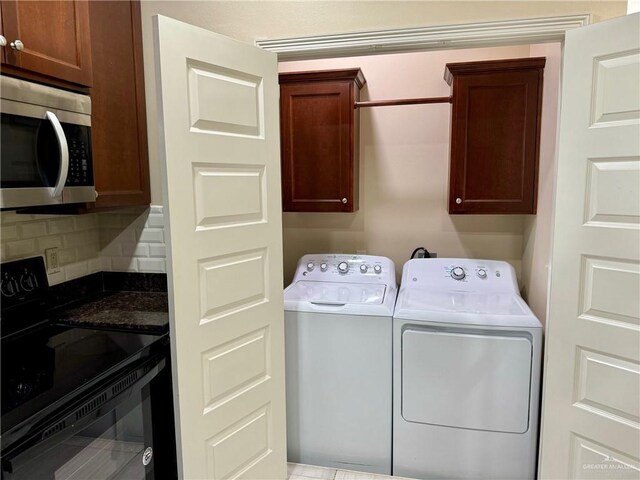 clothes washing area featuring washer and dryer and cabinet space