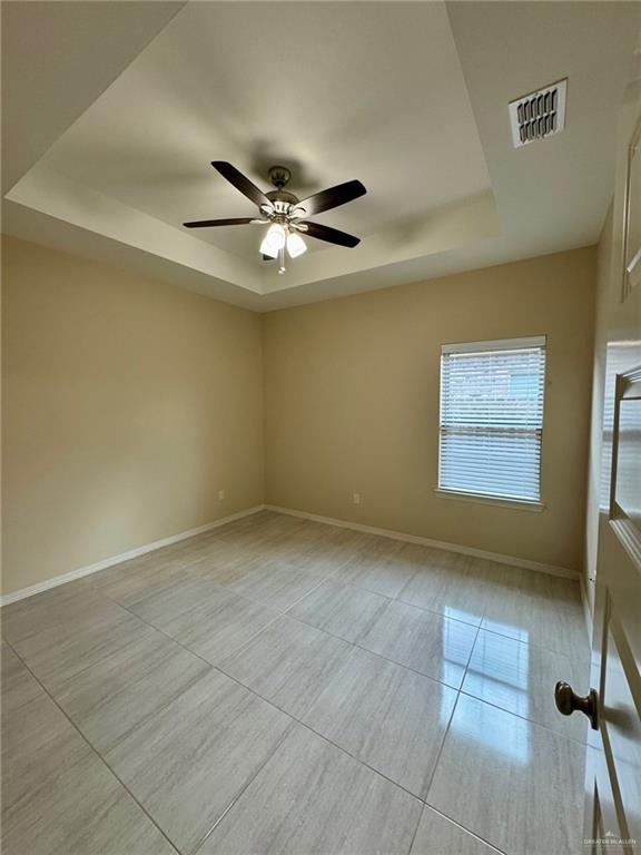 2611 E Eisenhower Ave, Mission, TX 78573 - spare room featuring baseboards, visible vents, a raised ceiling, and light tile patterned flooring