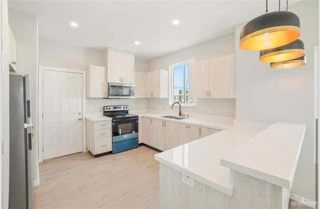 kitchen featuring sink, stainless steel appliances, kitchen peninsula, light hardwood / wood-style floors, and decorative light fixtures