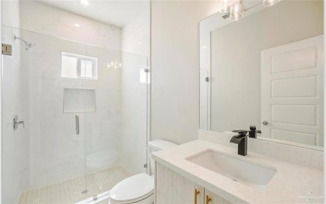 bathroom featuring vanity, an enclosed shower, and toilet