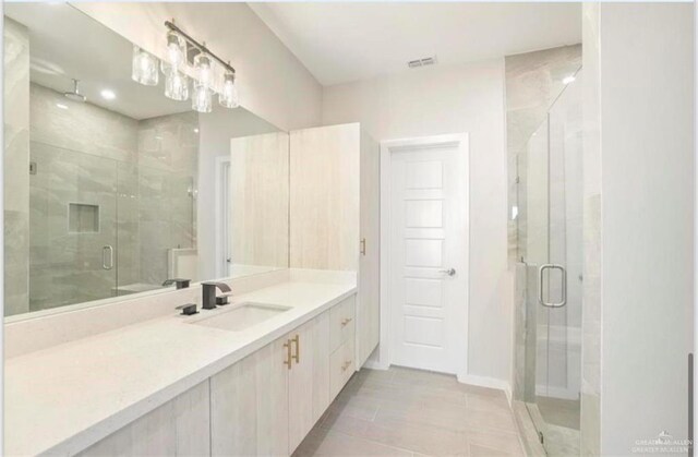 bathroom with tile patterned floors, vanity, and an enclosed shower