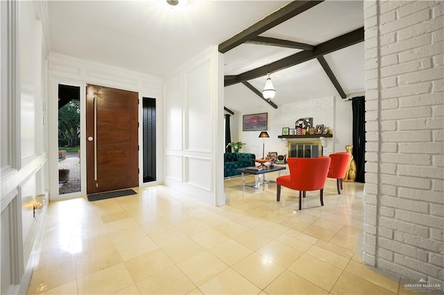 tiled foyer entrance with vaulted ceiling with beams and a brick fireplace