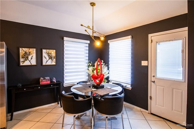 dining space with light tile patterned floors and an inviting chandelier