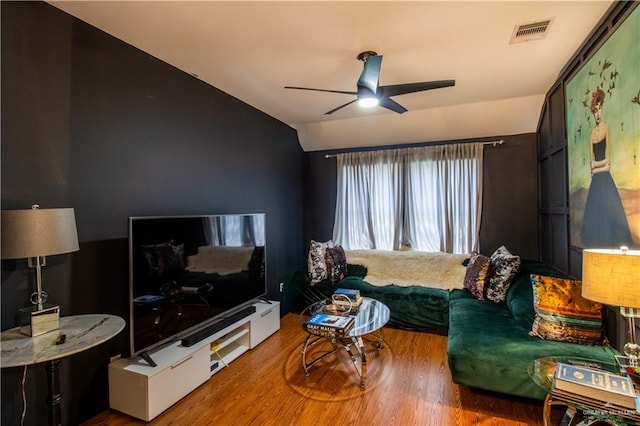 living room featuring hardwood / wood-style flooring, ceiling fan, and vaulted ceiling