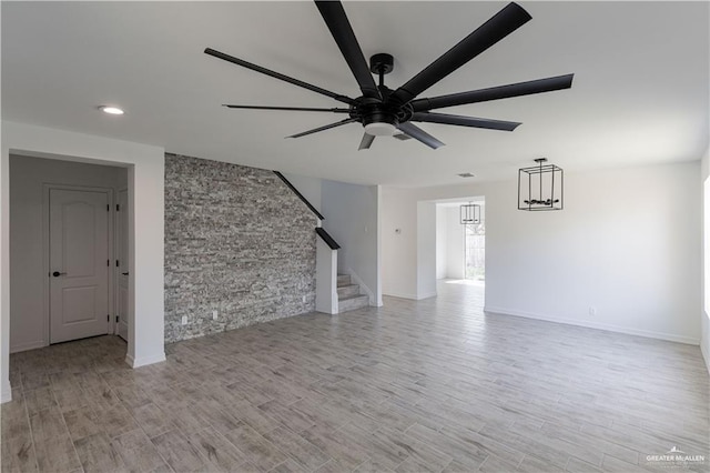 unfurnished living room featuring baseboards, ceiling fan, light wood-type flooring, recessed lighting, and stairs
