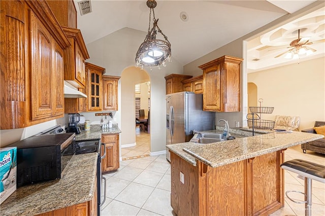 kitchen with a breakfast bar, lofted ceiling, sink, light tile patterned flooring, and kitchen peninsula