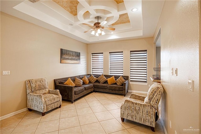 tiled living room with ceiling fan, a raised ceiling, and coffered ceiling