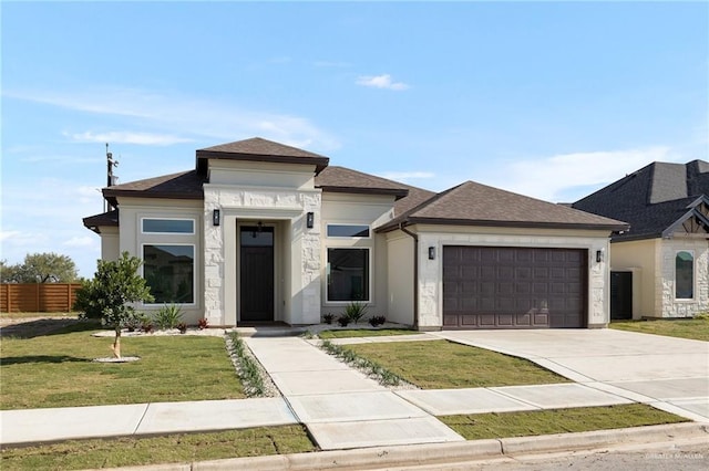 prairie-style house with a garage and a front lawn