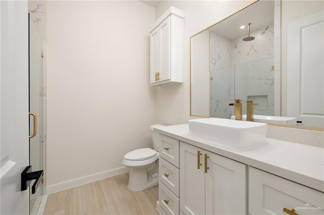 bathroom featuring vanity, wood-type flooring, an enclosed shower, and toilet