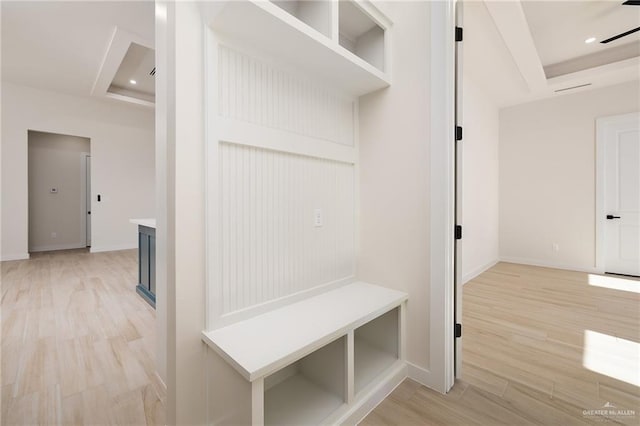 mudroom featuring light wood-type flooring and a raised ceiling