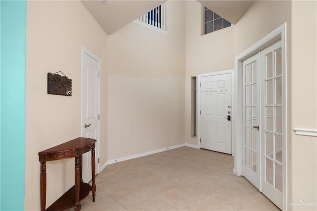 tiled foyer entrance with french doors and a high ceiling