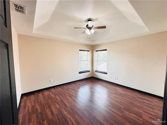 3106 Salvador Ave, Edinburg, TX 78539 - empty room featuring a raised ceiling, ceiling fan, dark wood finished floors, and baseboards