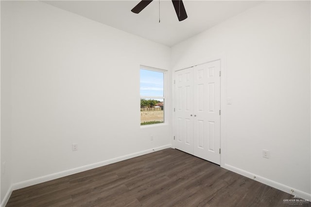 unfurnished bedroom featuring dark hardwood / wood-style flooring, a closet, and ceiling fan